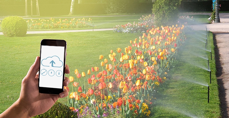 smart irrigation controller installed in a residential backyard garden